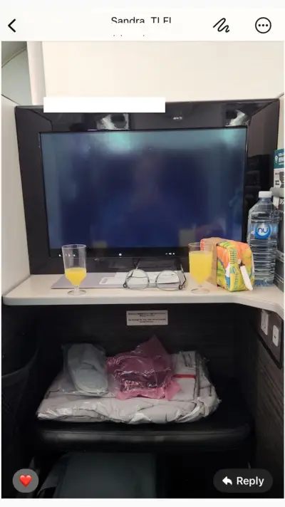 Sandra's Business Class suite — TV screen, amenities, slippers and bedding pre-flight
